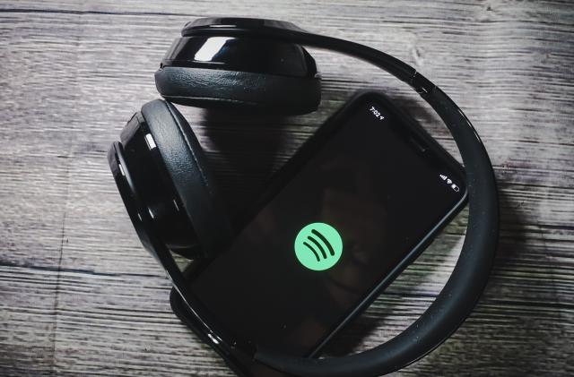 An iphone 11 screen showing spotify icon with beats earphone, perfect for listening musics on the go