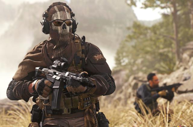 A still image from 'Call of Duty: Modern Warfare 2' showing two soldiers in tall grass. One wears a skull mask and sunglasses as he heads toward the camera with a gun raised.