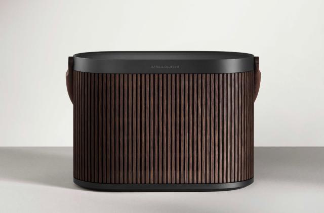 The Bang & Olufsen Beosound A5 speaker, which looks like a combination of an air filter and lunch pail, sits on a grey surface in front of a white wall.