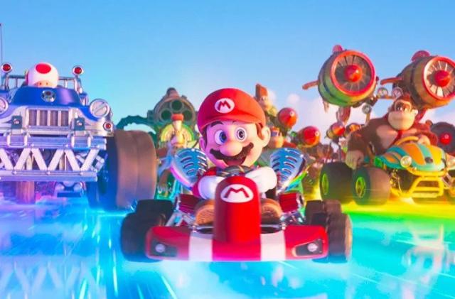 Mario races down a track with Toad and Donkey Kong behind him. 